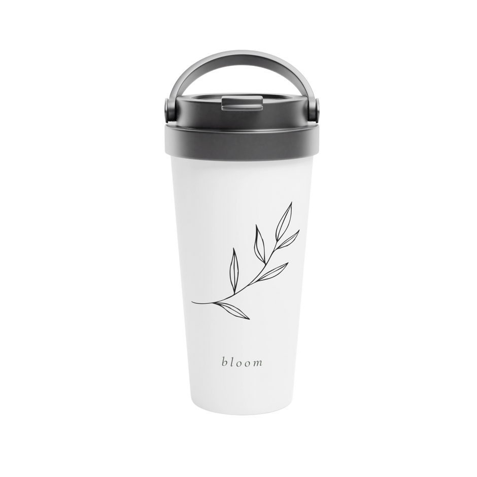 A white travel tumbler with a dark gray lid and handle, featuring a minimalist black leaf branch illustration and the word 'bloom' printed near the bottom.